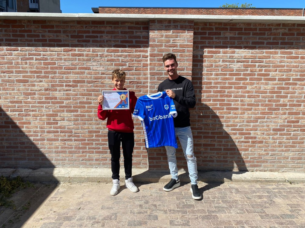 De winnaar krijgt het truitje van KRC Genk overhandigd.