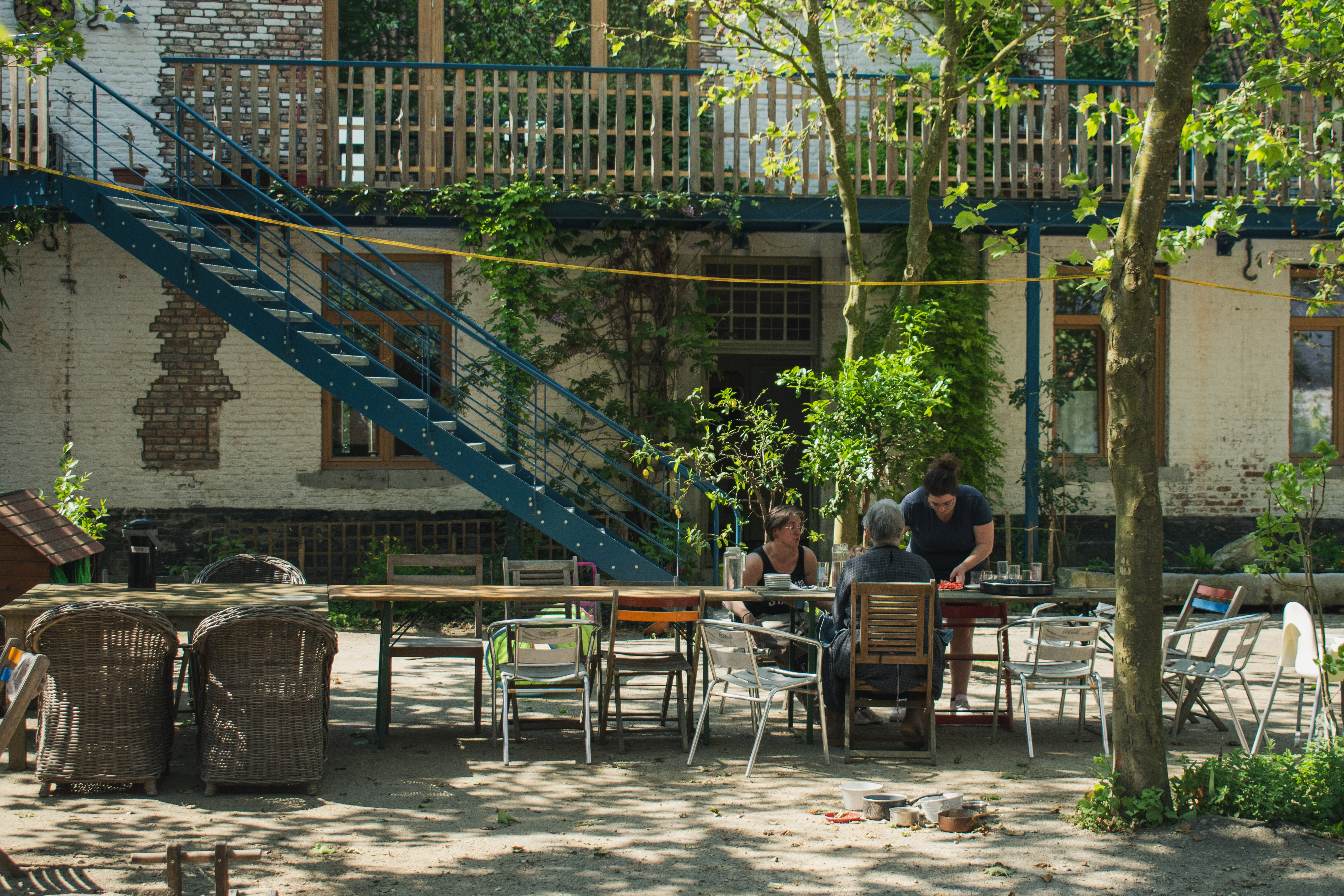Bewoners eten samen op de binnenplaats van Het Abtshof (© Lowie Vandyck)