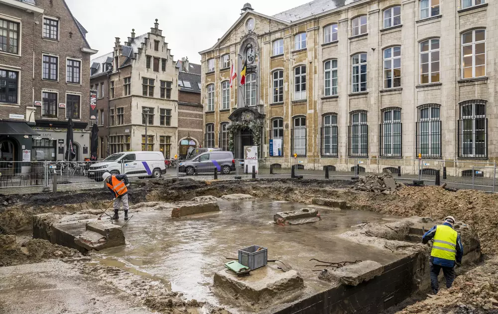 Afbeelding van een blootgelegde bunker onder de Vrijdagsmarkt in Antwerpen, met op de achtergrond het Museum Plantin-Moretus.
