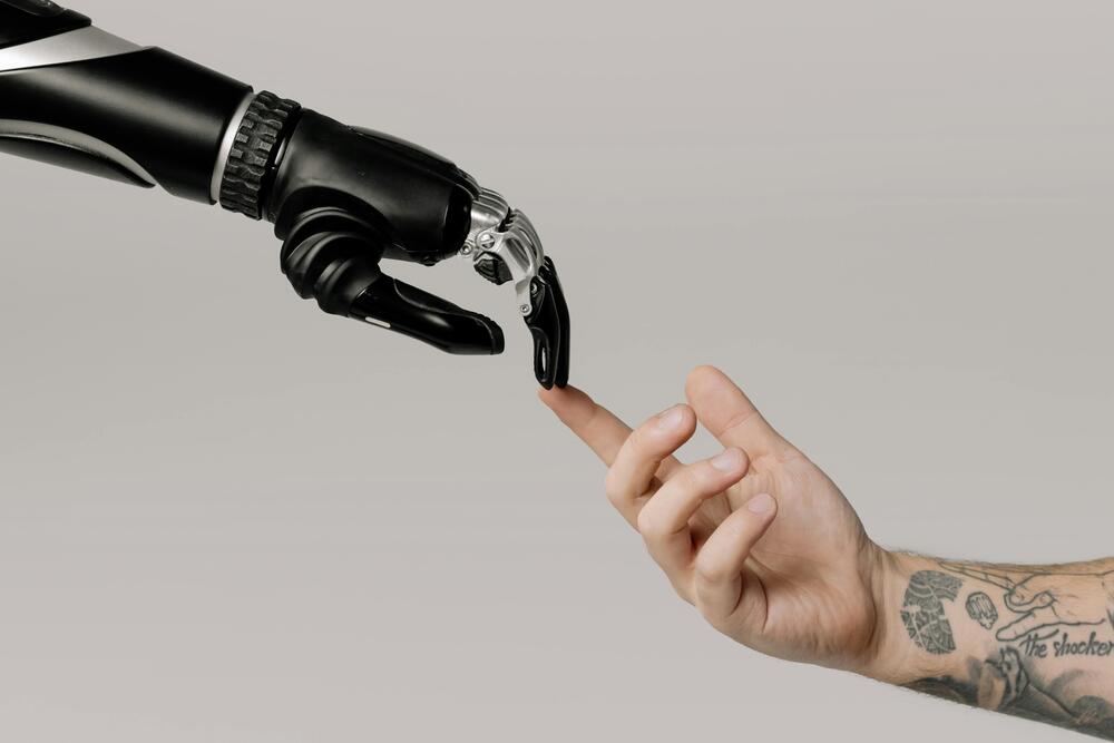 Bionische hand en menselijke hand met uitgestoken vinger