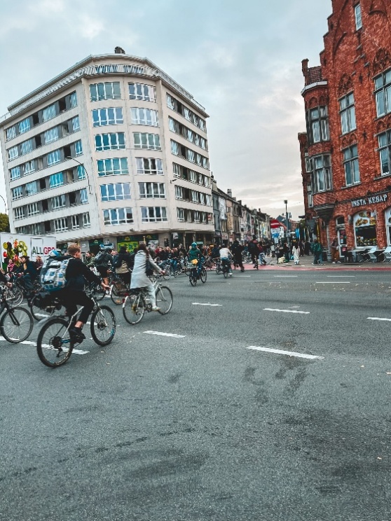 A group of people riding bicycles in a city</p>
<p>AI-generated content may be incorrect.