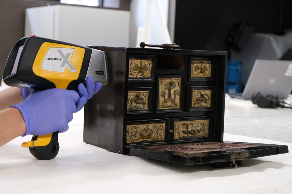 De foto toont het uitvoeren van de chemische analyse met behulp portable-XRF om de materialen en technieken van het zwartgekleurde hout op dit 17de-eeuws kabinet te identificeren. DIVA Antwerpen (inv. S58/66)