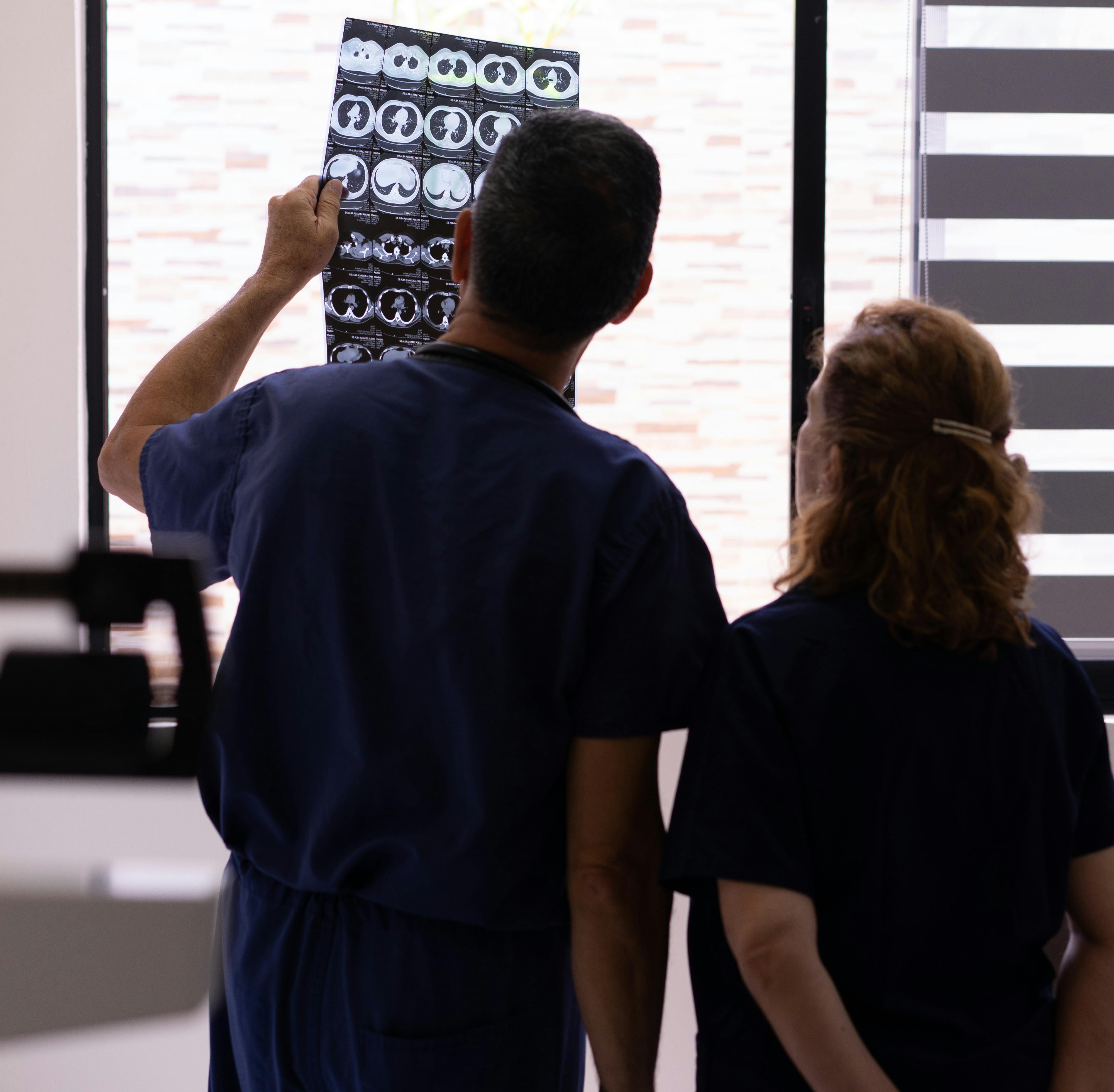 Two Doctors Analysing MRI brain scans together, emphasizing the importance of collaboration